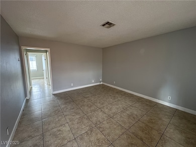 Tiled empty room featuring baseboards, visible ven
