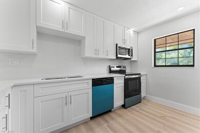 Kitchen featuring stainless steel appliances, light wood finished floors, white cabinetry, light countertops, and recessed lighting
