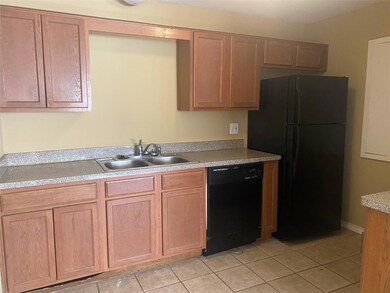 Kitchen featuring black appliances, light countert