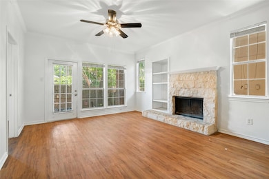 Unfurnished living room with ceiling fan, wood fi