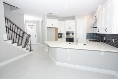 Just off the entrance is this fabulous open railing stairs Kitchen island can serve a dual purpose in your home for food prep and additional dining space!