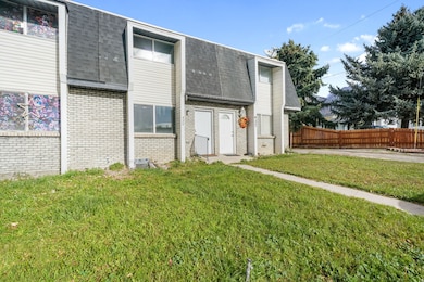 Entrance to property with brick siding, a shingled roof, and mansard roof