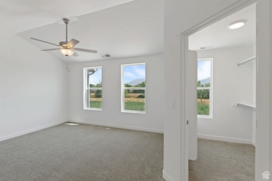 Empty room featuring carpet and a ceiling fan