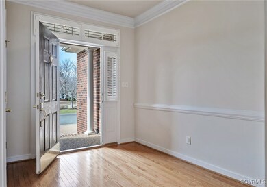 Entryway with light wood-type flooring and crown m