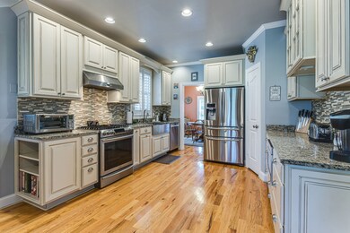 The updated kitchen  continues the hardwood floors and features beautiful custom cabinetry.