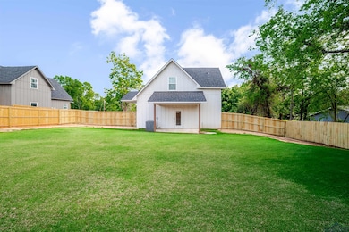Back of house with a shingled roof and a fenced backyard