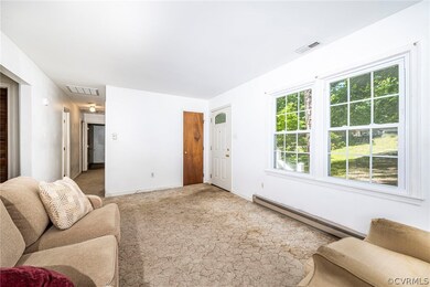 Carpeted living room with a baseboard heating unit