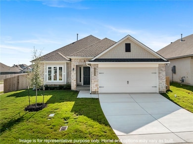 View of front of home featuring roof with shingles, driveway, brick siding, and a garage