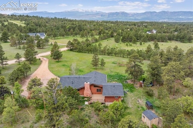 View from above of property with mountains and a heavily wooded area
