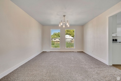 Unfurnished dining area with carpet flooring and a chandelier