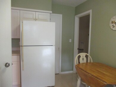 Kitchen featuring white cabinetry and white fridge