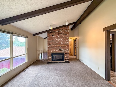 Living room featuring a textured ceiling, carpet, and a fireplace