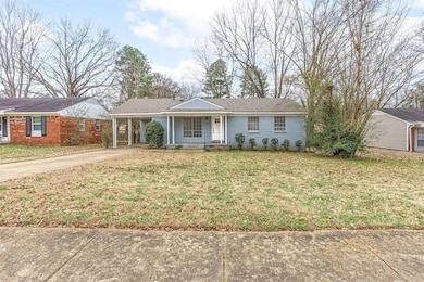 Ranch-style house featuring driveway, a front lawn, a porch, brick siding, and an attached carport