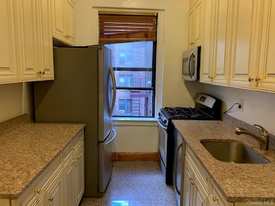 Kitchen with stainless steel appliances and light stone counters
