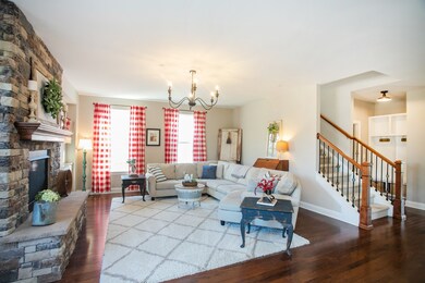 View looking at living room toward garage entry and stairs