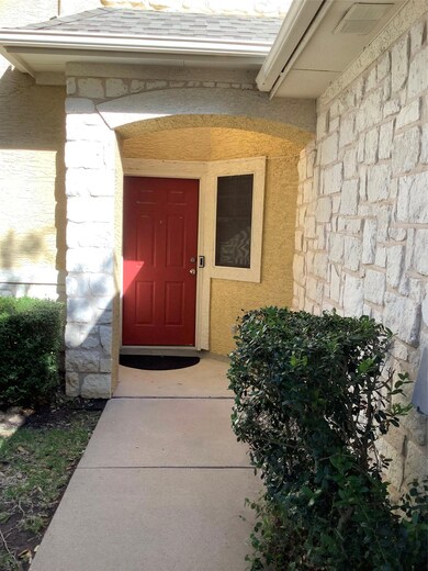 Entrance to property with a shingled roof, stone 