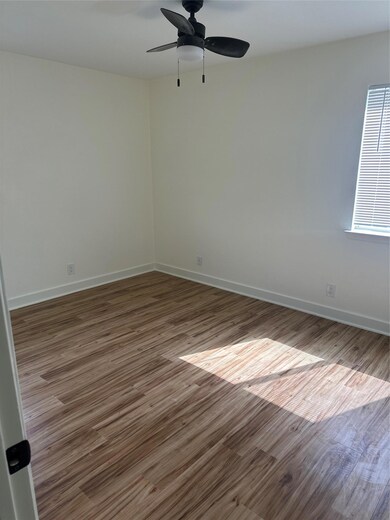 Empty room featuring a ceiling fan and wood finis