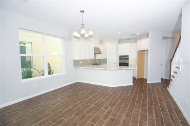 Just off the entrance is this fabulous Great room for entertaining! The noticeable open concept Kitchen, Dining & Gathering room offers plenty of space for a large table and seating with tons of natural light!