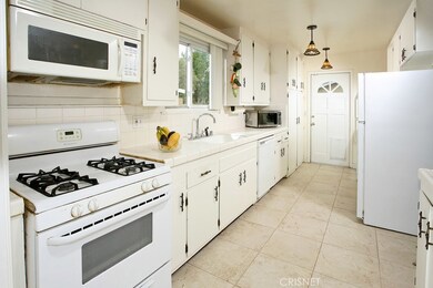 The family’s chef is going to truly appreciate the well-appointed galley kitchen’s pendant lighting, abundant cabinets, tile counters with back-splash, gas range, refrigerator/freezer, easy care flooring, and adjacent dining area.