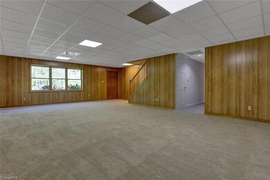 Great Room: Room features include carpet flooring, recessed ceiling lights, paneled wall coverings, three windows for natural lighting, the entry door to the rear patio and backyard. The stairs lead up to the main level and the hallway on the right side is to a full bathroom, two bedrooms, a nice sized storage room with carpet flooring and wire racks and then the mechanical room plus a closet as shown in the hallway.