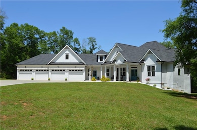 Modern farmhouse style home with a front lawn, covered porch, a shingled roof, and concrete driveway