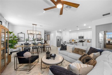 Living room featuring a ceiling fan, recessed lighting, and a chandelier