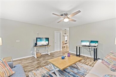 Living room with ceiling fan with notable chandeli
