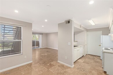 Kitchen with crown molding, white cabinets, recess