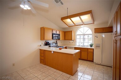 Well-lit kitchen with solid surface countertops, a