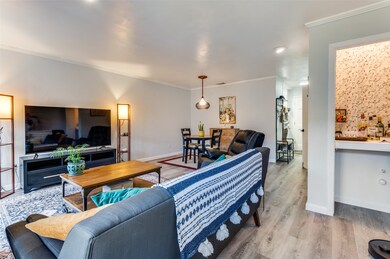 Living room with ornamental molding and wood finished floors