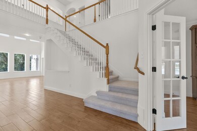 Stairway with baseboards, wood finished floors, a
