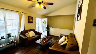 Living room featuring a ceiling fan, lofted ceilin
