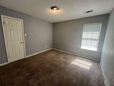 Carpeted spare room featuring a textured ceiling