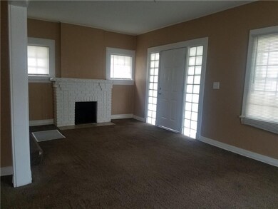 Living room has decorative fireplace in entry