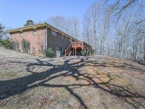 View of side of property featuring a wooden deck