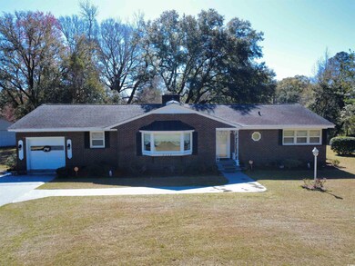 Ranch-style home with brick siding, a front lawn, 