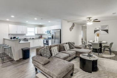 Living room with ceiling fan, light hardwood / woo