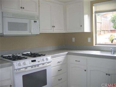 Clean and bright kitchen with tile counters, 10 ye