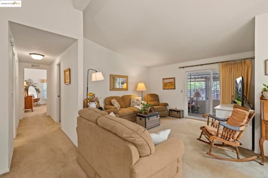 Living area featuring light colored carpet and lofted ceiling