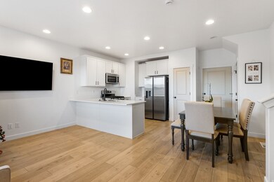 Kitchen featuring white cabinets, recessed lighting, appliances with stainless steel finishes, a peninsula, and light wood-style flooring