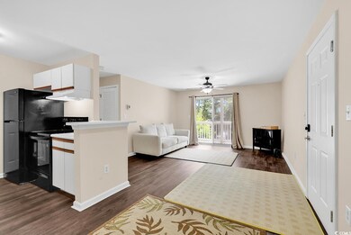 Living area with dark wood finished floors and ceiling fan