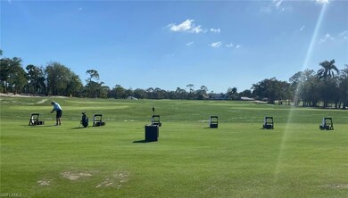 View of property's community with view of golf course, view of scattered trees, and a lawn