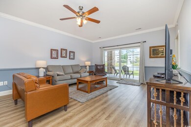 Living room with crown molding, light wood-type fl