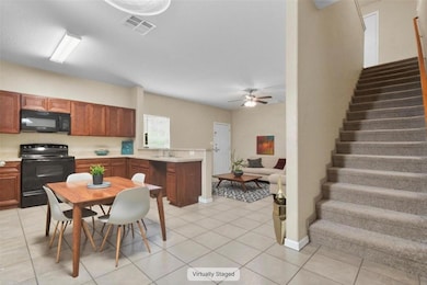Kitchen featuring black appliances, light tile pa