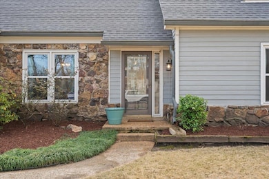 Property entrance featuring stone siding and roof 