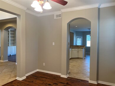 The dining room opens to both the entry and the kitchen. It has high ceilings and crown moulding.