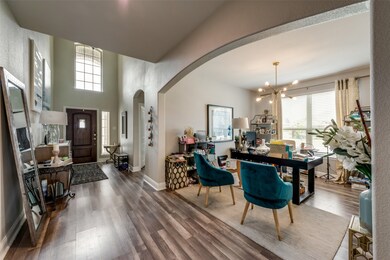 Foyer with arched walkways, healthy amount of natural light, and wood finished floors
