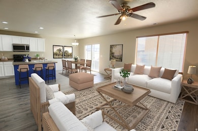 Living room with dark wood-type flooring, a textured ceiling, recessed lighting, and ceiling fan