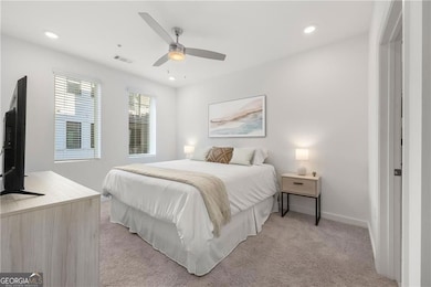 Carpeted bedroom featuring ceiling fan