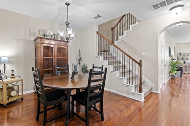 The dining room is just off the front entry with laminate wood floors and arched doorways.